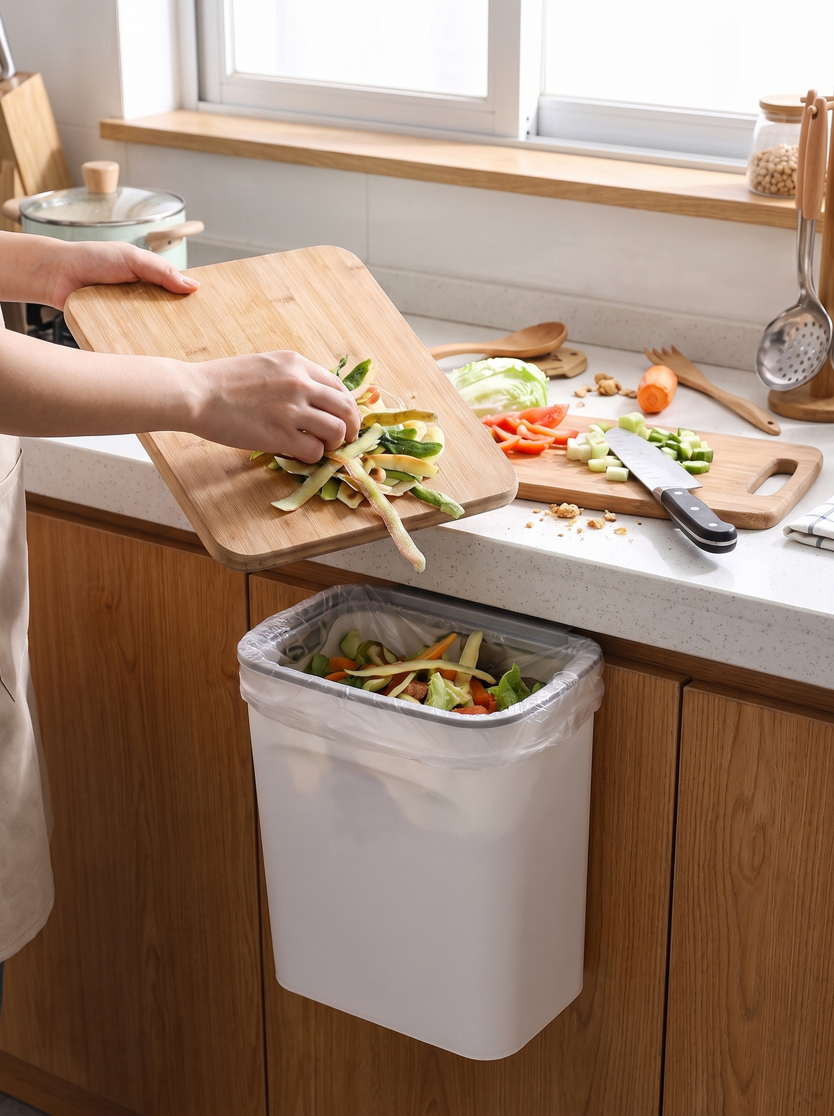 Scraping a chopping board into the wide bin opening